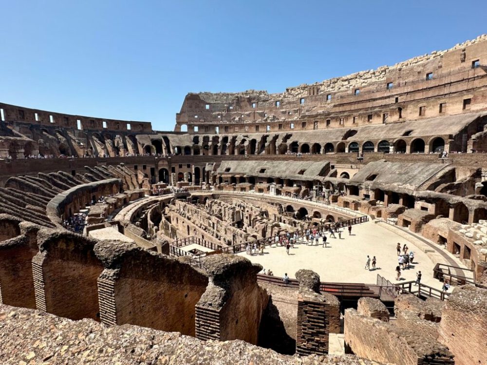a group of people standing in front of Colosseum