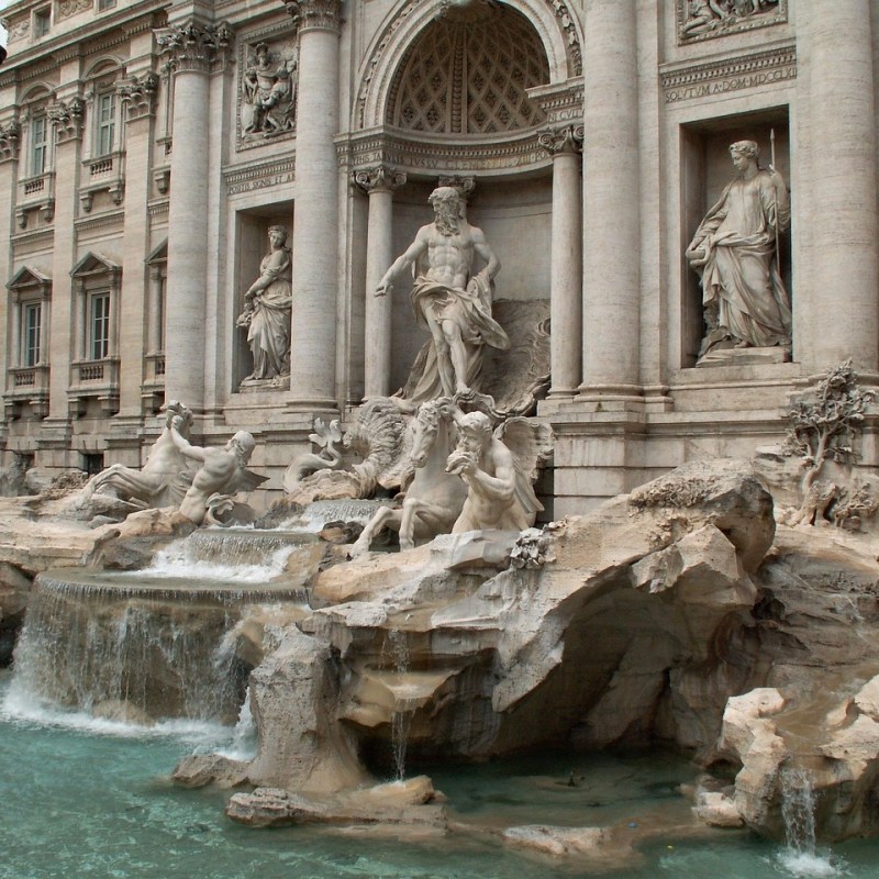 a large stone statue in front of Trevi Fountain