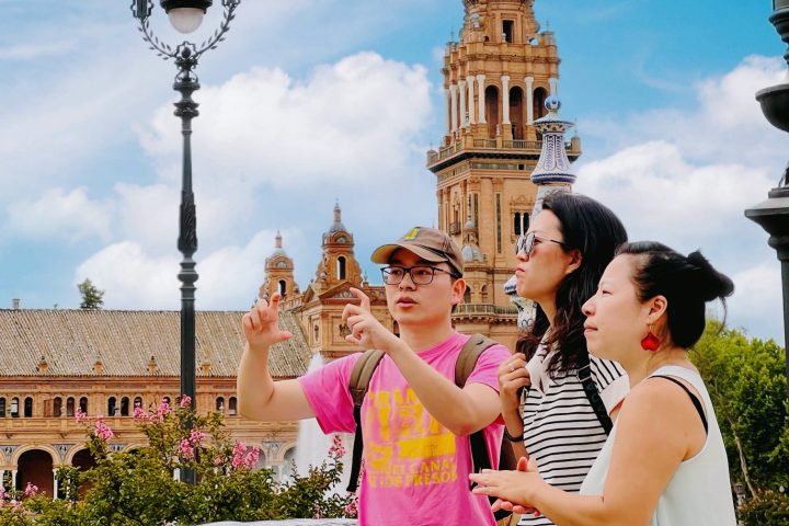 A group of people standing in front of a building during the Alcazar of Seville Tour