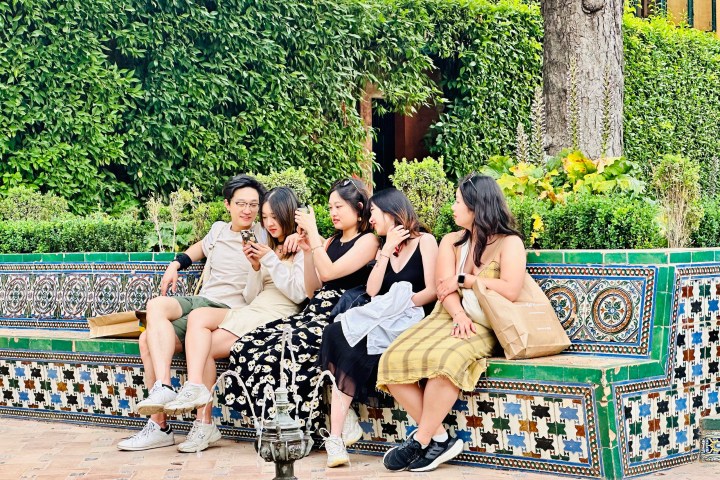 a group of people sitting on a bench in a park