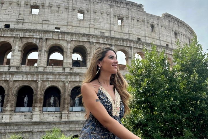 a woman standing in front of a stone building