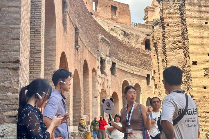 a group of people standing in front of a brick building