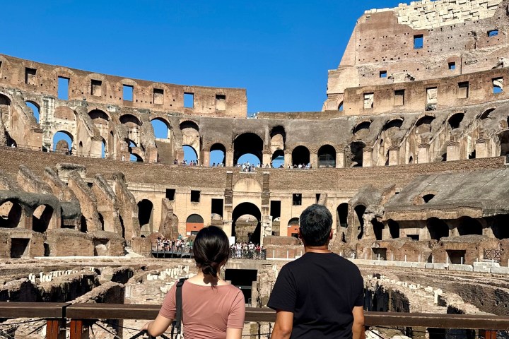 a group of people standing in front of Colosseum