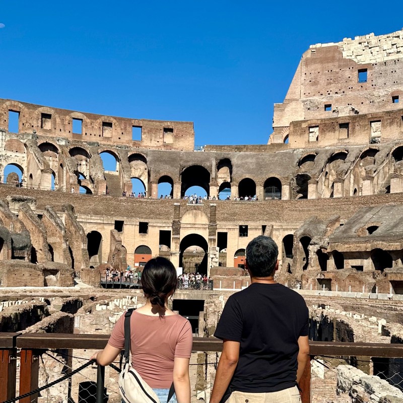 a group of people standing in front of Colosseum