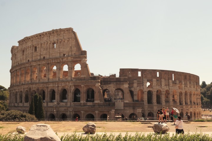 a large stone building with Colosseum in the background