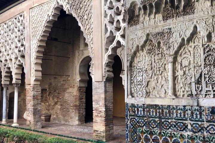 Ornate arches and patterned walls in historic architecture with intricate carvings and tiles.