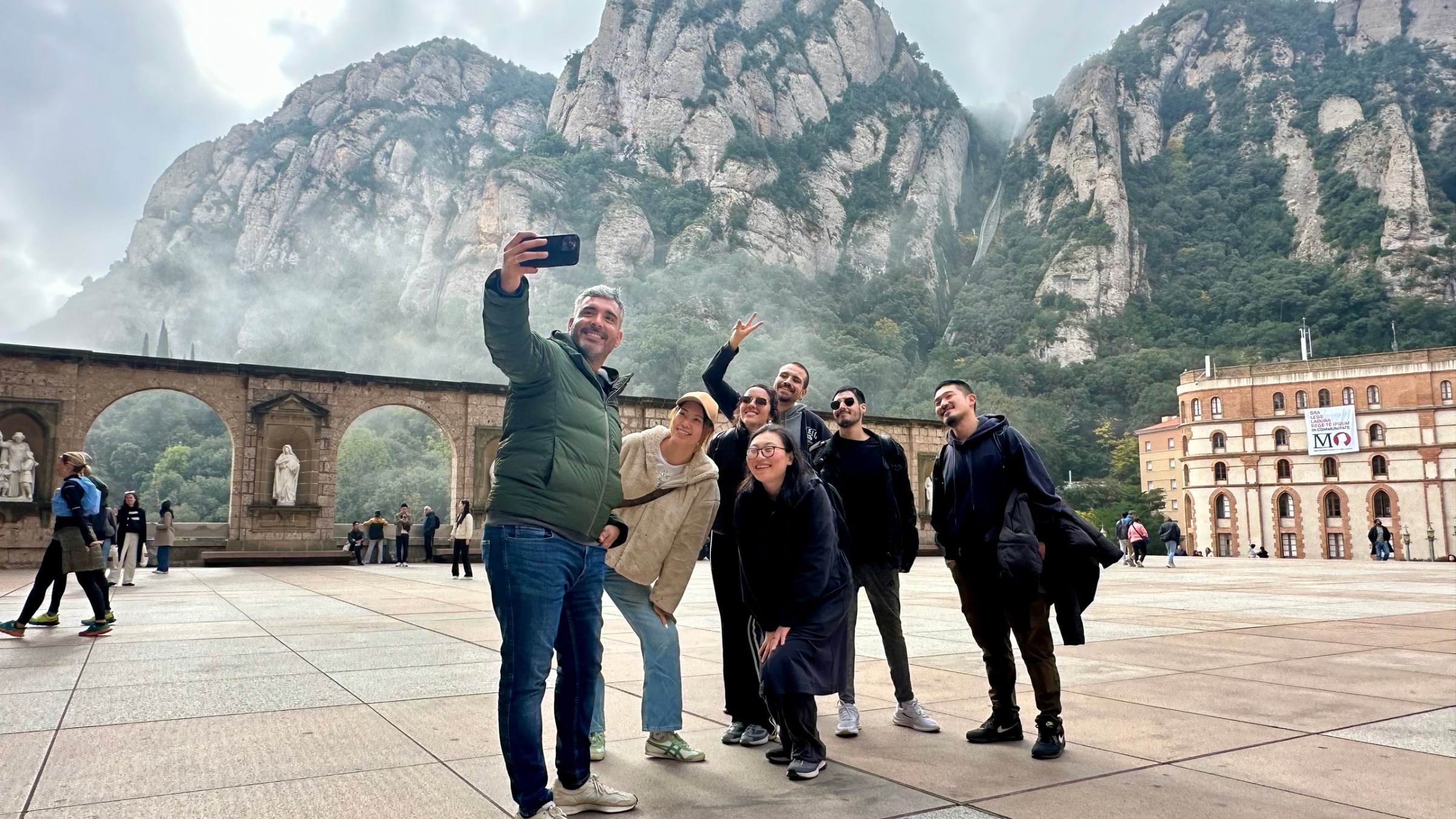 a group of people walking in front of a mountain