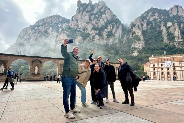 a group of people walking in front of a mountain