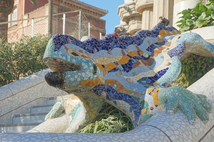 a statue of a stone building with Park Güell in the background