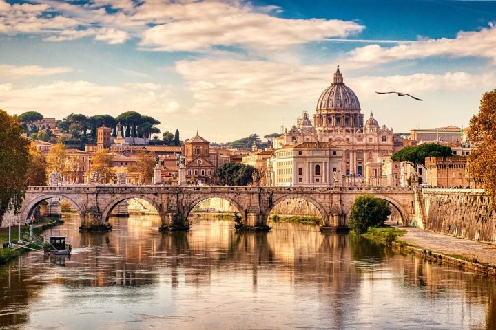 a bridge over a body of water with a city in the background