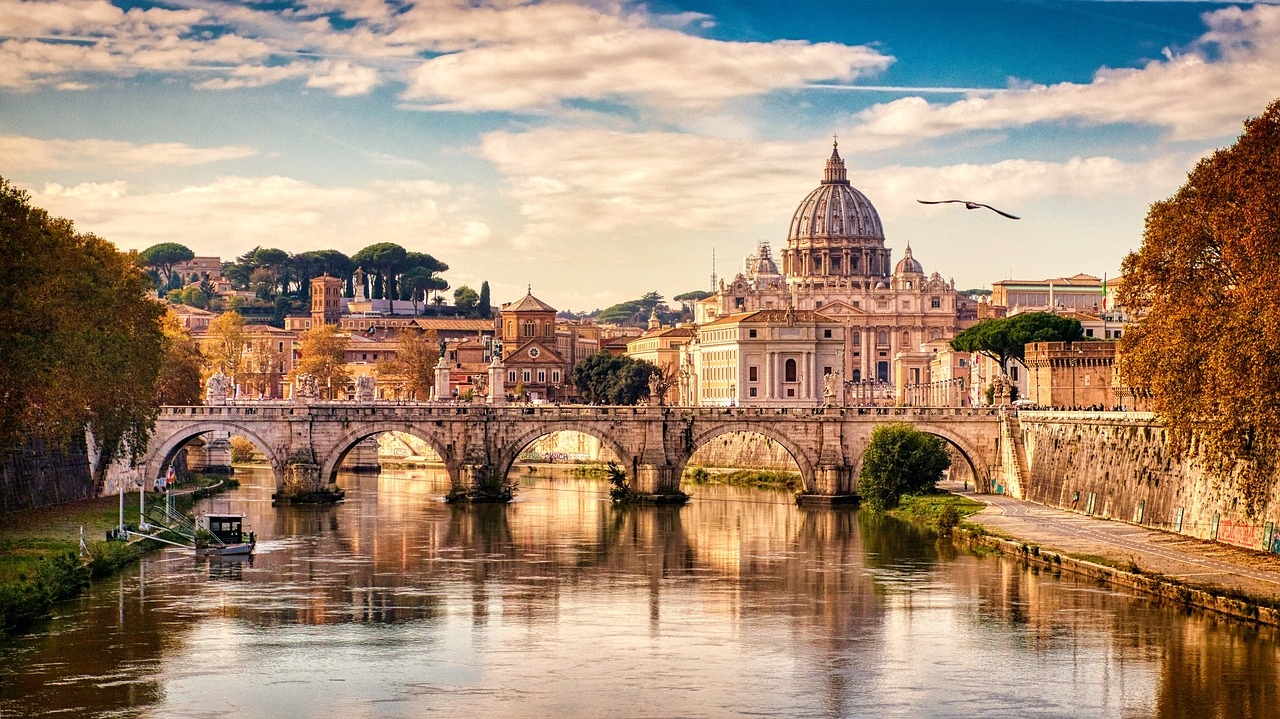 Rome Day Tour: the Vatican and the Colosseum Image 1 a bridge over a body of water with a city in the background
