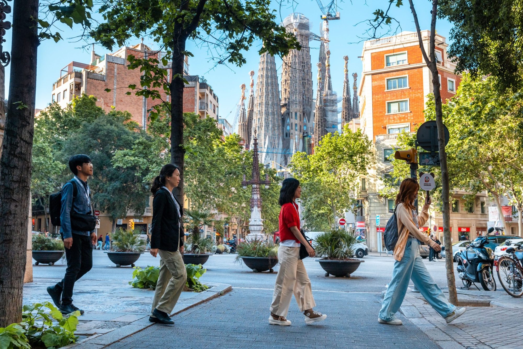 a group of people on a sidewalk during the sagrada familia tour