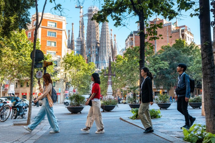 a group of people on a sidewalk during the sagrada familia tour