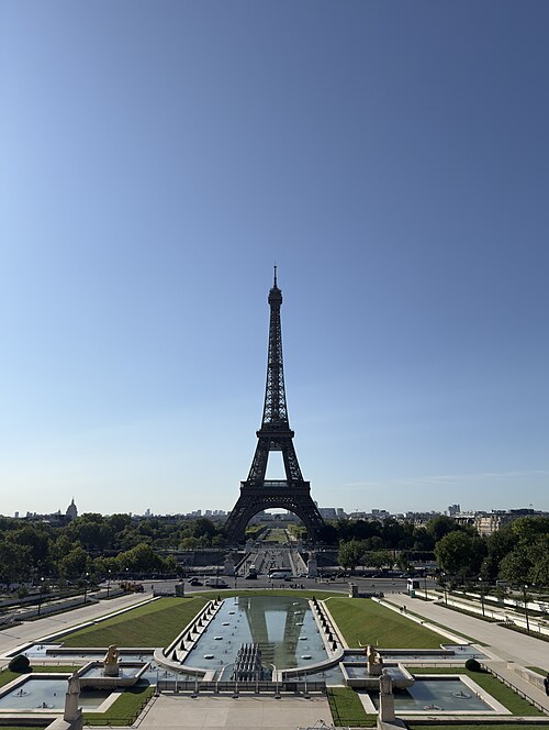 Eiffel Tower with reflecting pool and clear blue sky in the background.