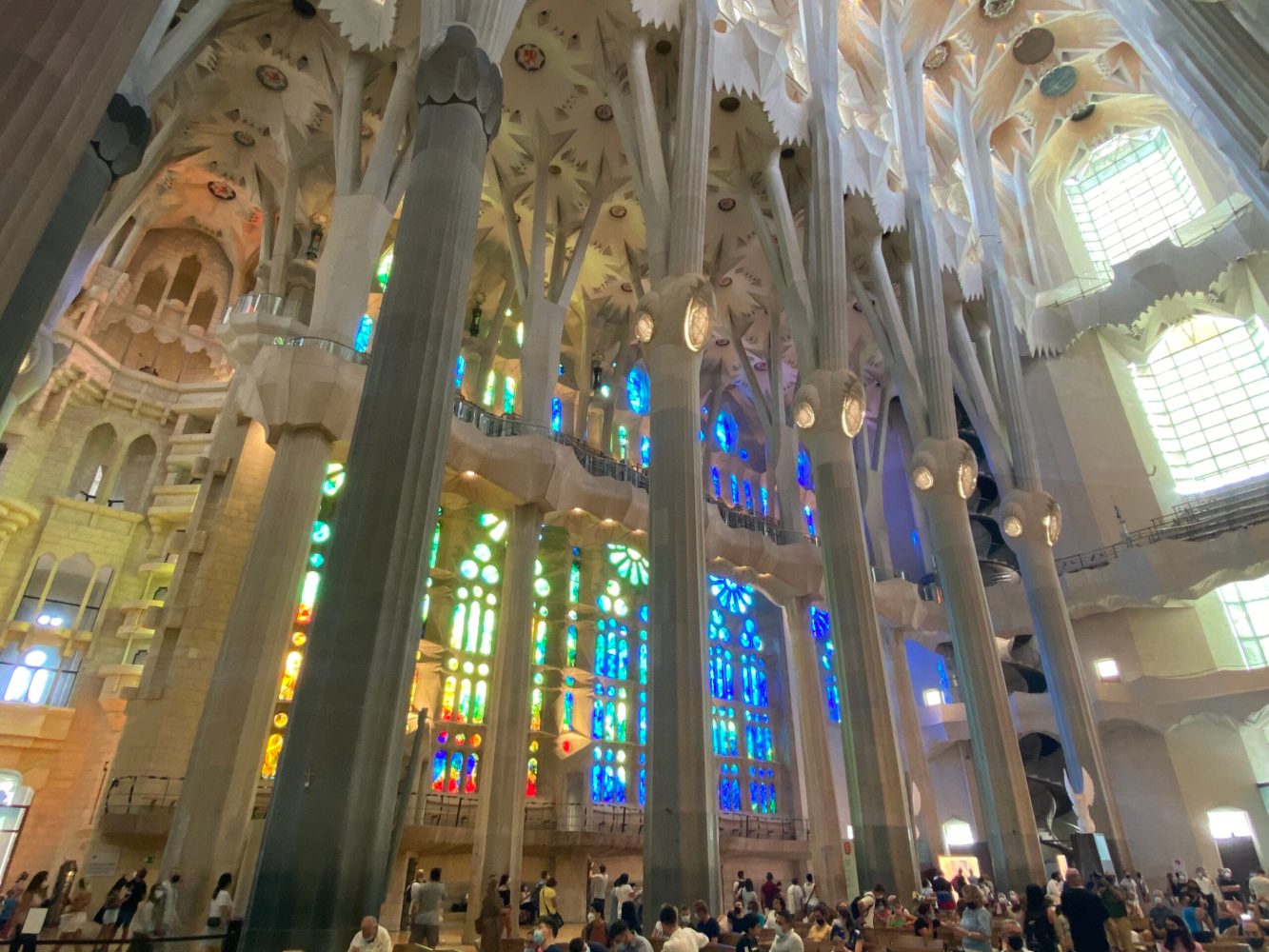 Interior of a cathedral with tall columns and colorful stained glass windows.