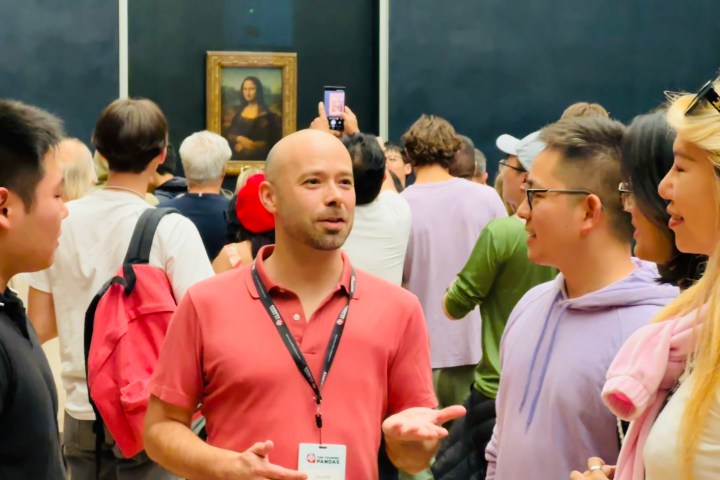 A group of people in a gallery looking at a painting on the wall.