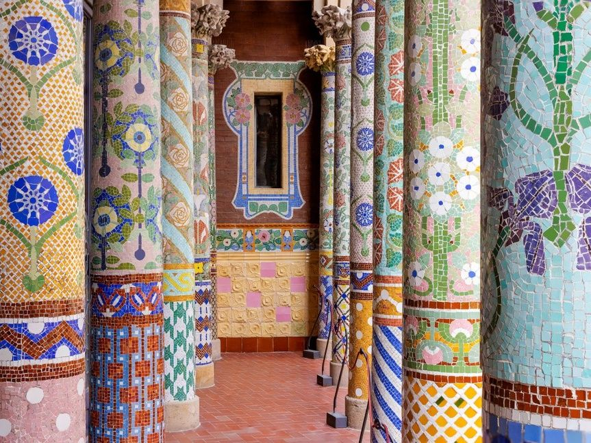 Ornate columns with colorful mosaic tiles in a corridor.