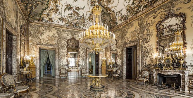 Ornate baroque room with chandeliers, elaborate wall decor, and luxurious furniture.