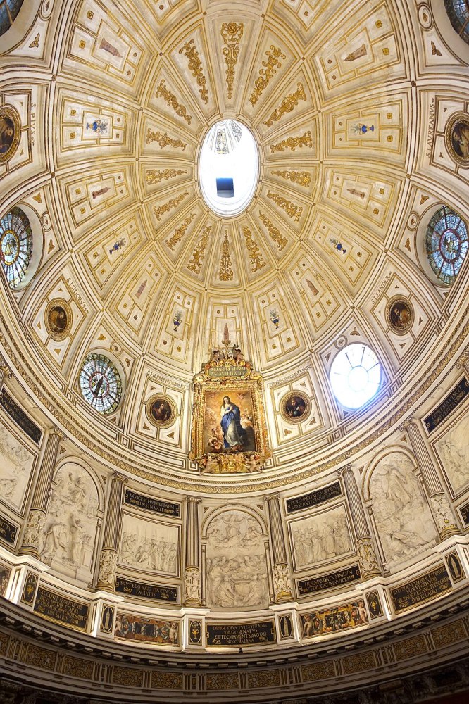 Ornate dome interior with religious painting and circular skylight.