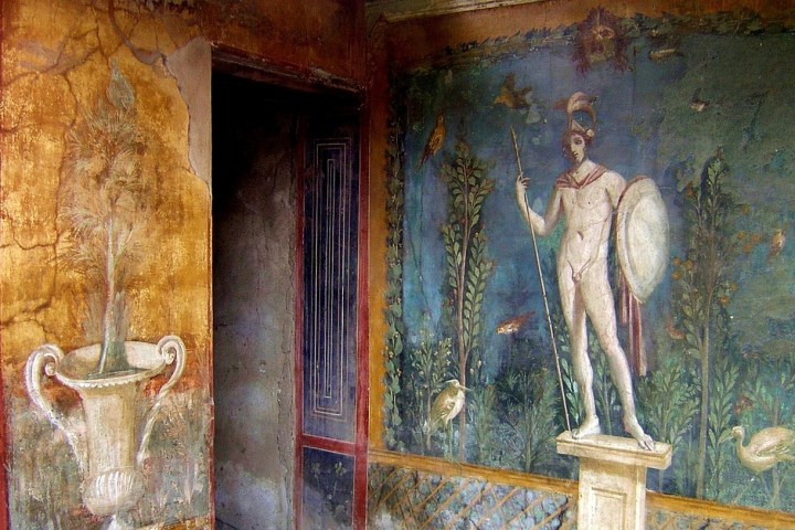 Ancient wall fresco with a warrior and shield beside a vase with a plant.