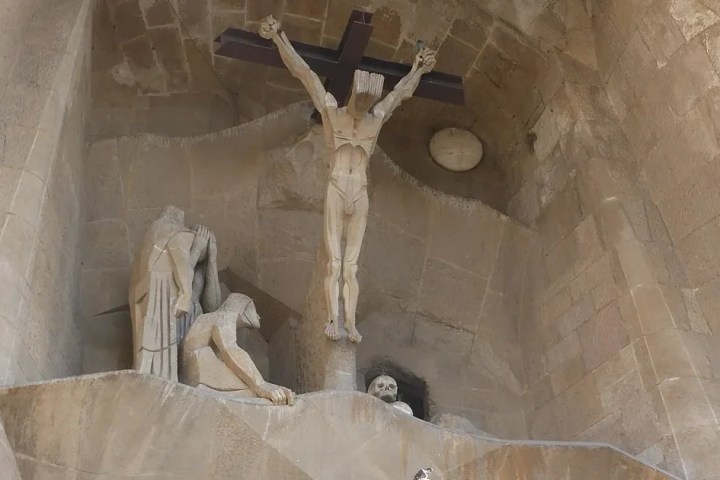 Stone sculptures depicting the Crucifixion scene in a church façade.