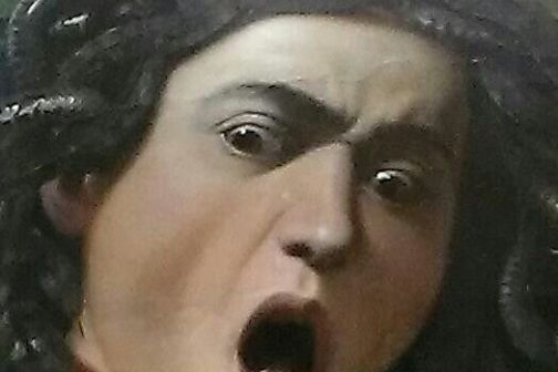 Painting of a head with snakes for hair, mouth open, expressing shock or fear.