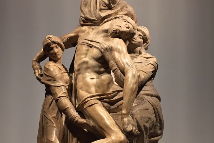 Marble sculpture of a group with a central hooded figure holding a limp body.