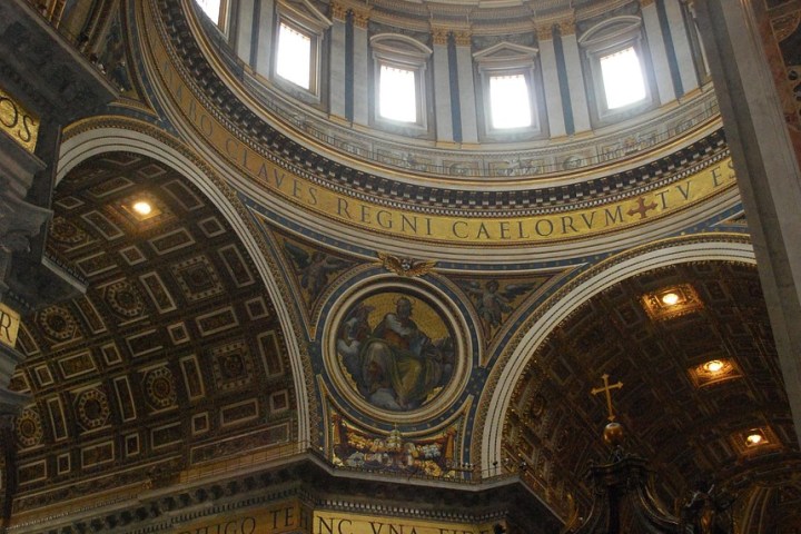 Ornate cathedral interior with dome, columns, and religious artwork.