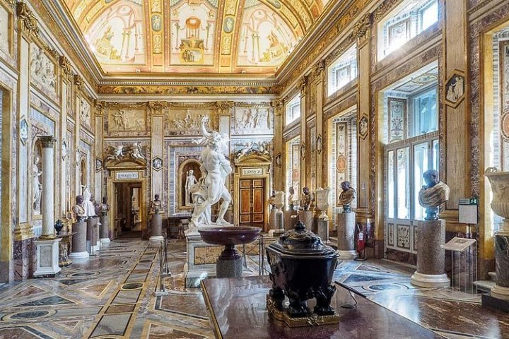 Ornate museum hall with classical sculptures and marble decorations.