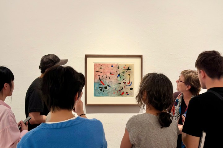 People observing abstract art in a gallery setting.