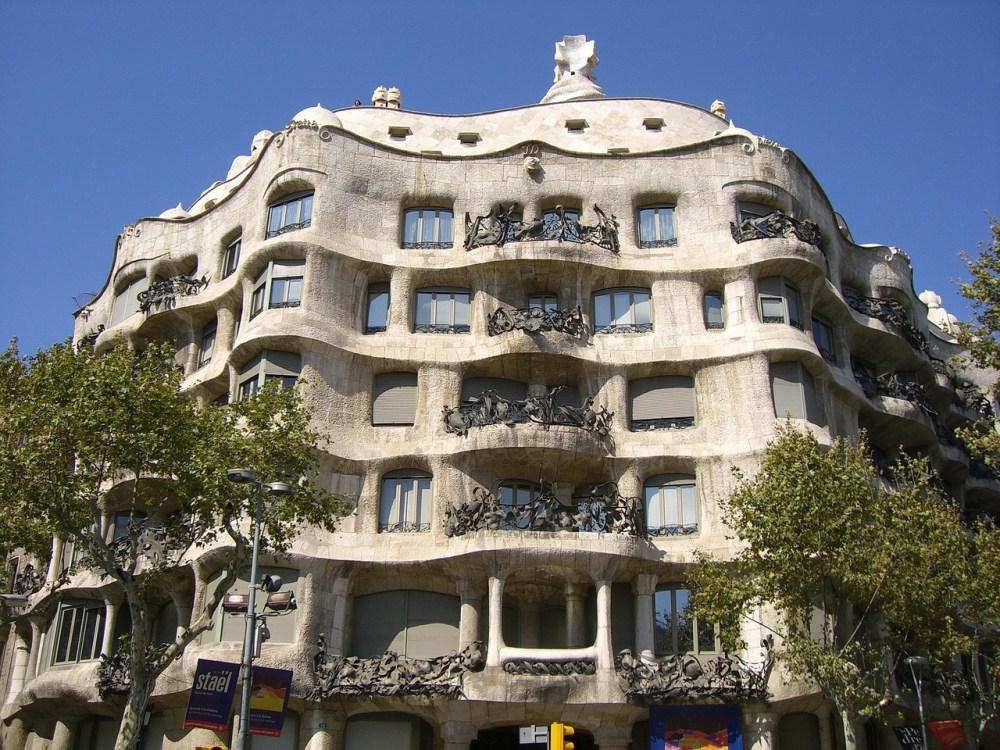 Curved architecture of a multi-story stone building with ornate balconies.