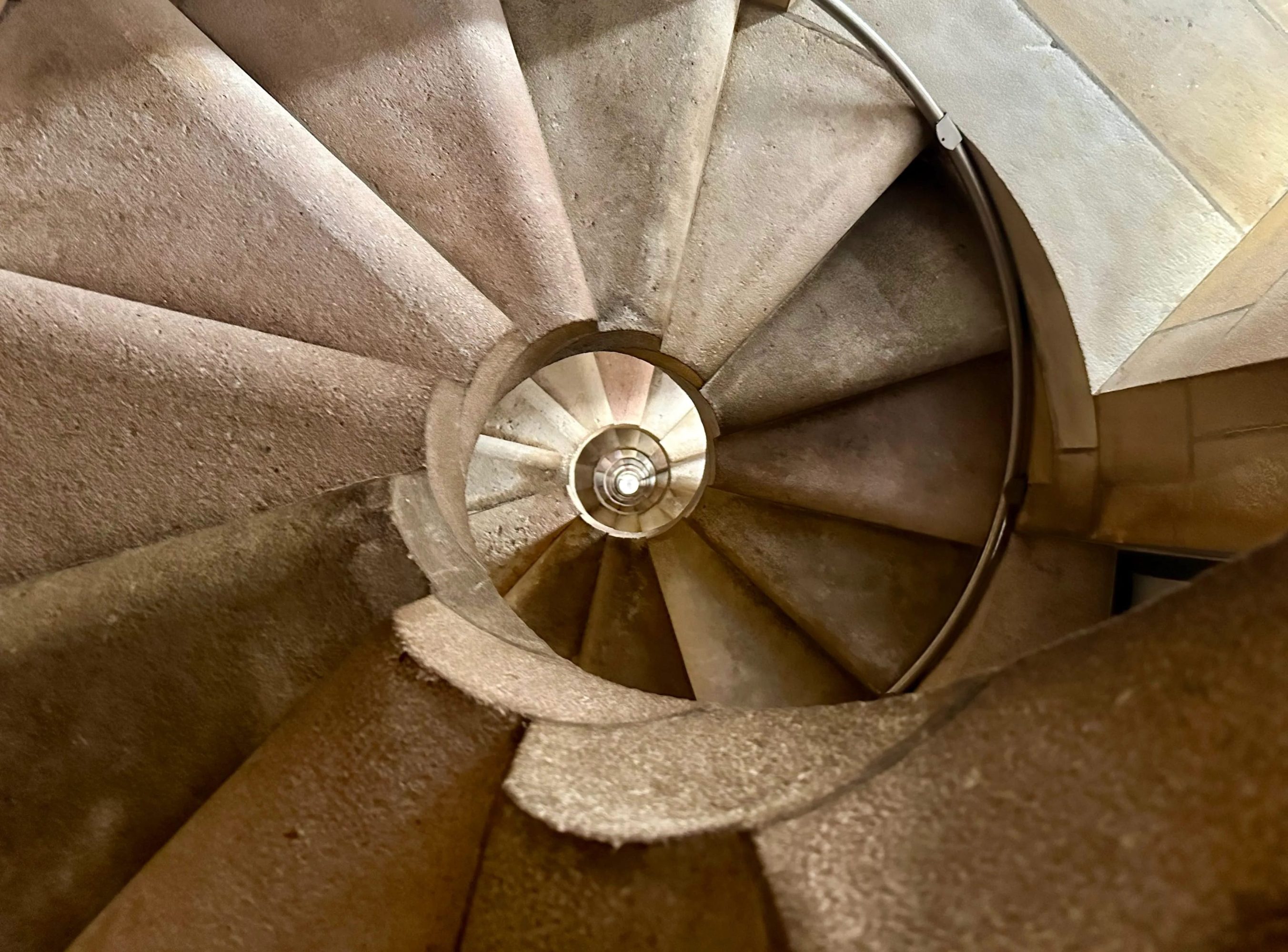 Spiral stone staircase view from above, creating a swirling pattern in the center.