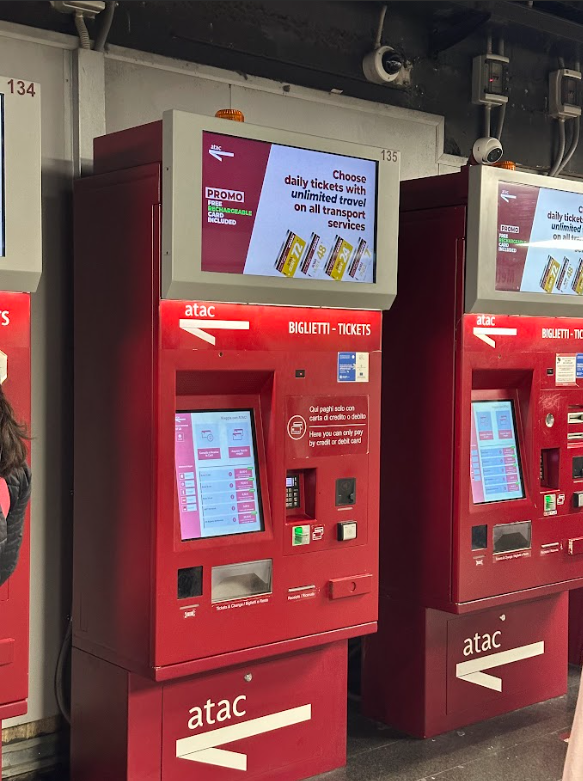 Red ticket machine for public transport with digital screen.