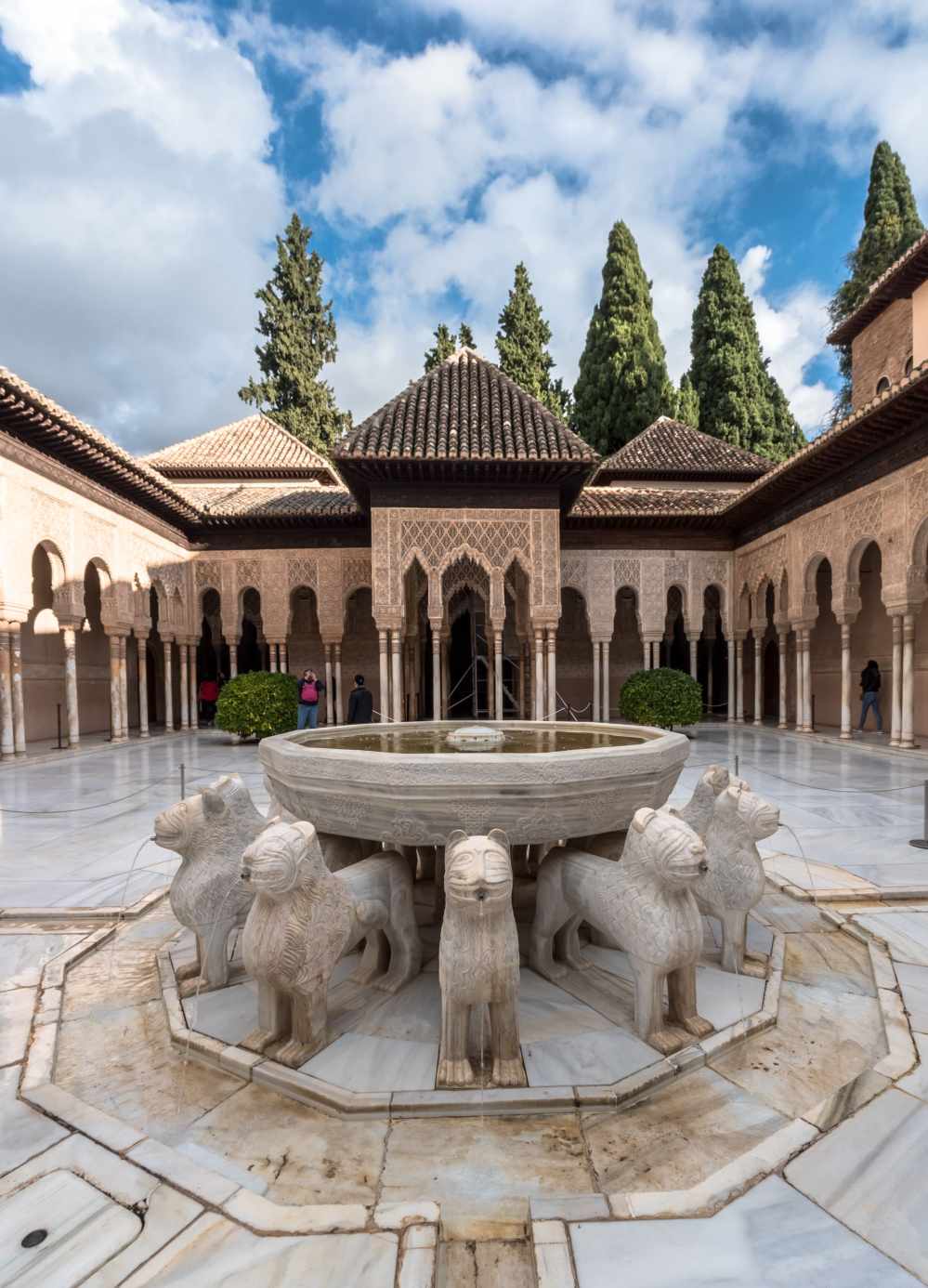 Courtyard with lion fountain, arches, and trees at Alhambra Palace.